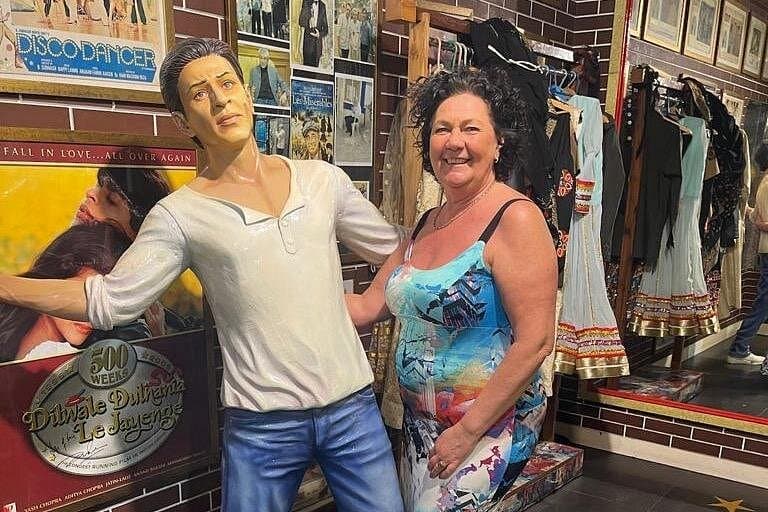 A guest beside a life-size film-star figure in the costume gallery