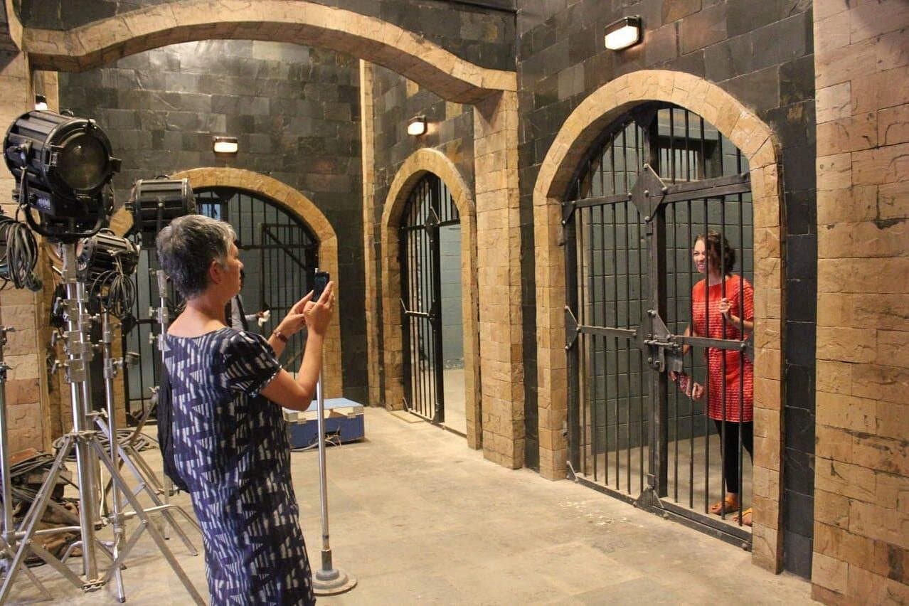 A guest photographing a jail set under studio lights