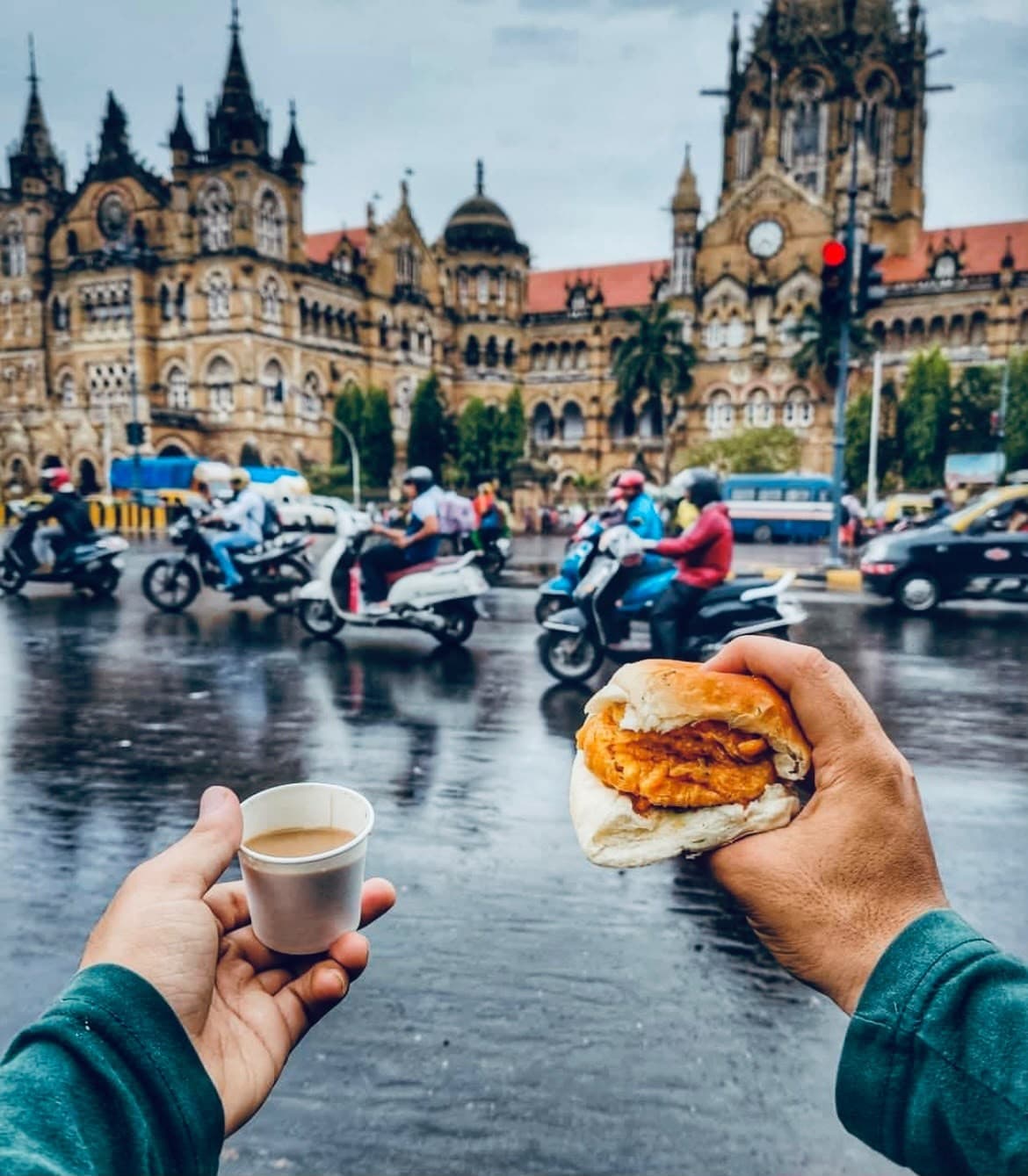 Chai and vada pav held up in front of CST