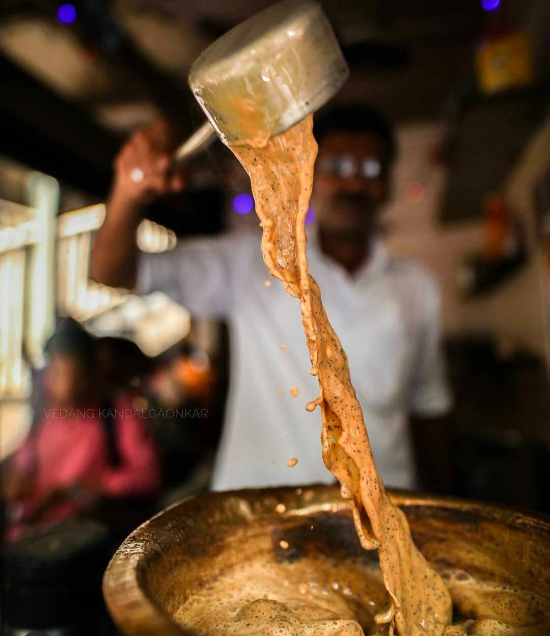 A chai-wallah pouring tea